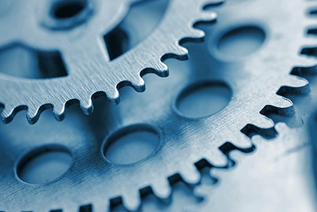 Two toothed steel gears with copy space and focus to the smaller gear at the top in a concept of industry and engineering