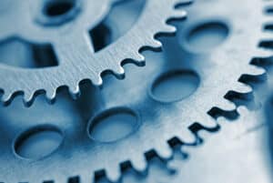 Two toothed steel gears with copy space and focus to the smaller gear at the top in a concept of industry and engineering